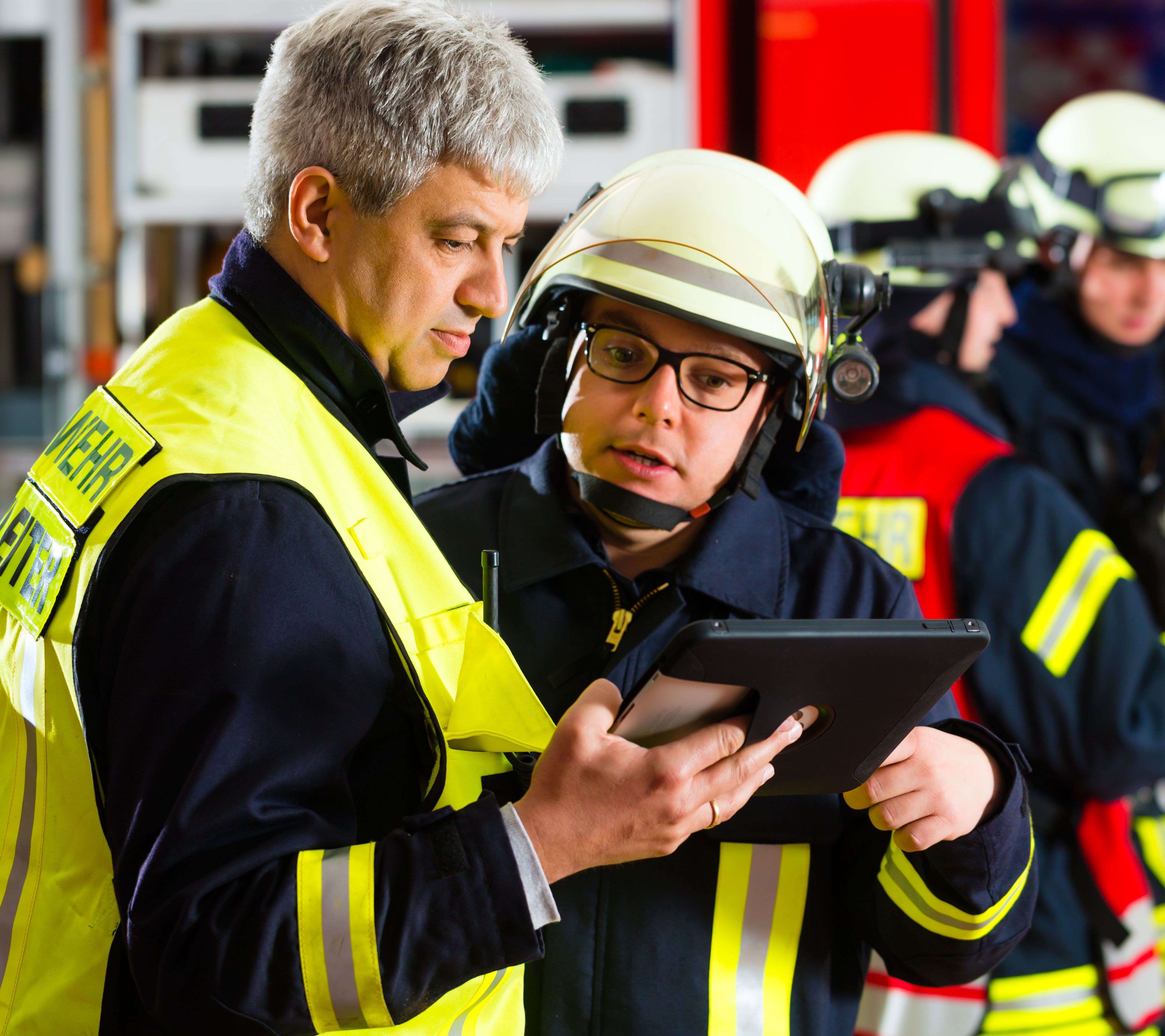 Einsatzleiter bei der Feuerwehr bespricht den Einsatz mit Feuerwehrmännern.