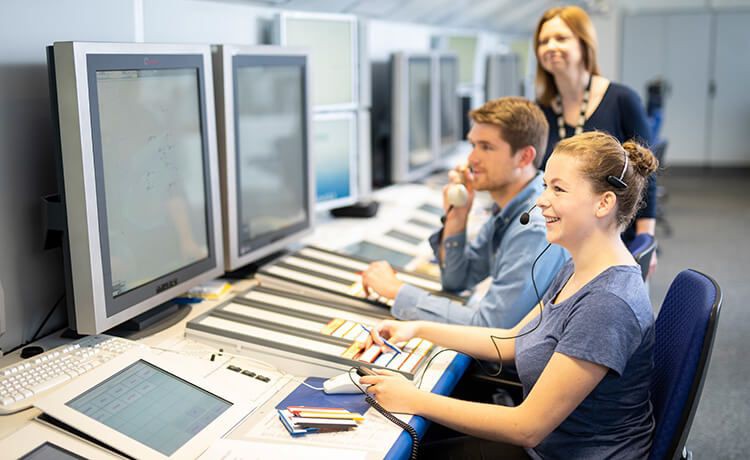 Junge Fluglotsin führt Simulationsübungen am PC durch.