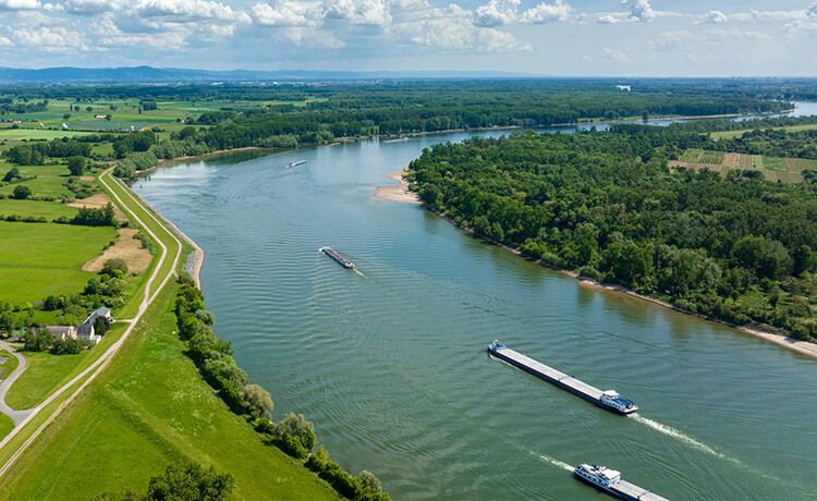 Mehrere Frachtschiffe fahren auf einem Fluss.